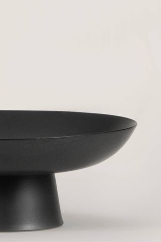 Matte black ceramic footed bowl, ideal for home decor and versatile for various contents like fruits and decorative items.