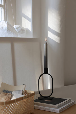 Elegant Eternal Oval Candle Holder in iron with a candle, set in a serene indoor space, showcasing minimalist design.