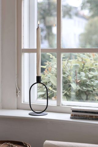 Eternal Oval Candle Holder on a windowsill with a tall candle, showcasing minimalist design and tranquility.