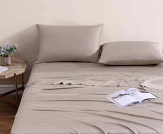 Natural premium bamboo sheet set featuring fitted sheet and two silky-soft pillowcases, stylishly arranged on a bed.