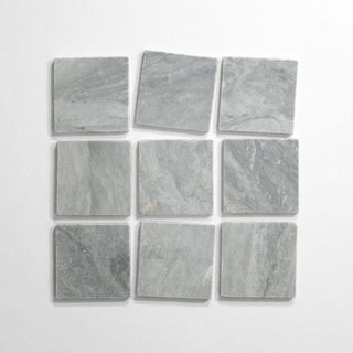 Bardiglio 4x4 tumbled marble tile display, featuring nine light gray tiles arranged in a grid pattern.