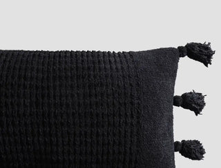 Braided Pom Pom Lumbar Pillow in black with textured cover and decorative pom poms, perfect for home decor.