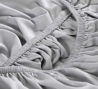 Close-up of a soft grey fitted sheet showcasing the silky texture and elastic edges of a bamboo sheet set.
