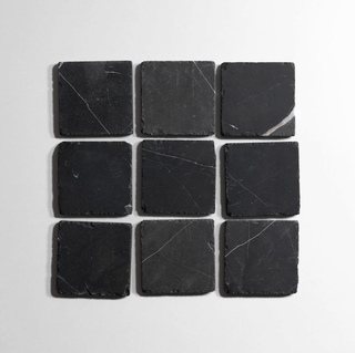 Nero St. Gabriel 6-inch tumbled stone tiles arranged in a grid, showcasing a sleek black finish.