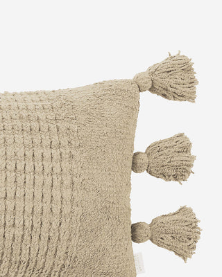 Braided pom pom lumbar pillow with a plush cover and three decorative tassels, perfect for stylish home decor.