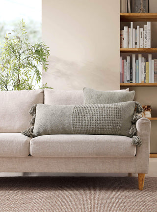 Braided pom pom lumbar pillow on a cozy sofa, featuring memory foam and a stylish removable cover.