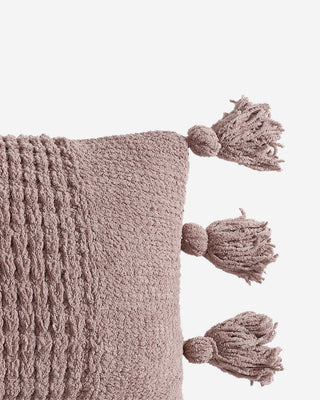 Braided pom pom lumbar pillow in soft fabric, featuring decorative tassels and a textured design, ideal for home decor.
