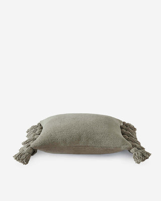 Soft olive green pom pom throw pillow with fuzzy ball accents, perfect for adding a cozy touch to any decor.