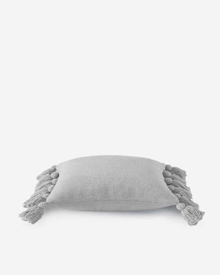 Soft gray pom pom throw pillow with fuzzy edges, made of memory foam and OEKO-TEX® certified microfiber.