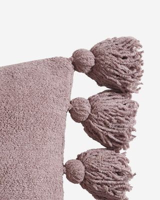 Soft pom pom throw pillow with fuzzy texture and decorative tassels in lavender color.