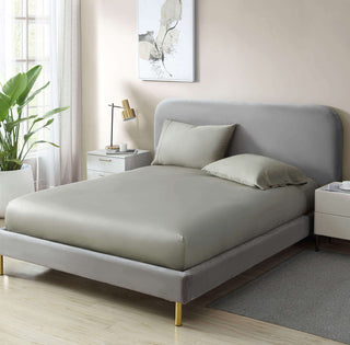 Natural premium bamboo sheet set on a modern bed with gray headboard and cozy pillowcases, featuring a silk-soft finish.