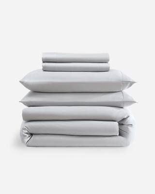 Premium bamboo bedding bundle featuring fitted sheet, flat sheet, pillowcases, and duvet cover in soft gray color.