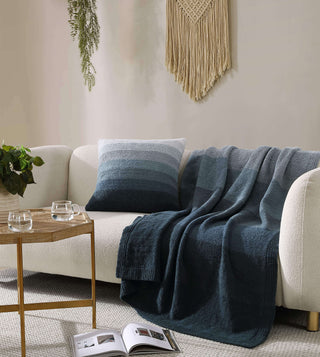 Transeasonal ombre throw pillow on a stylish sofa with a cozy throw and coffee table.