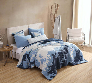 Double Snug Pixel Comforter in blue hues on a bed, featuring plush pillows and a modern bedroom decor.