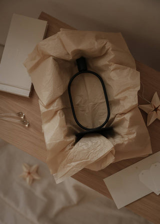 Eternal Oval Candle Holder in minimalist packaging on a wooden surface with decorative elements.