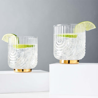 Gatsby Tumblers Set of 2, polished gold and glass double old fashioned glasses with lime slices, 12 oz capacity.
