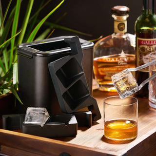 Glacier Rocks clear ice maker with mold, making crystal-clear ice cubes for cocktails on a wooden tray.